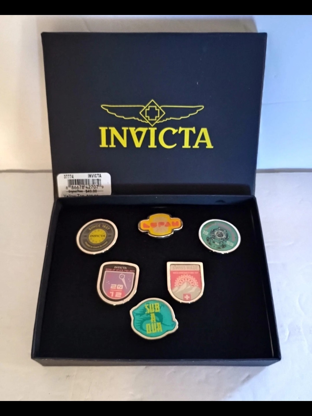 Invicta Black Box with Yellow Logo and Six Colorful Medallions